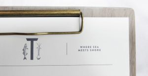 food menu on wooden clipboard, innovative restaurant logo design with seafood and vegetable illustrations